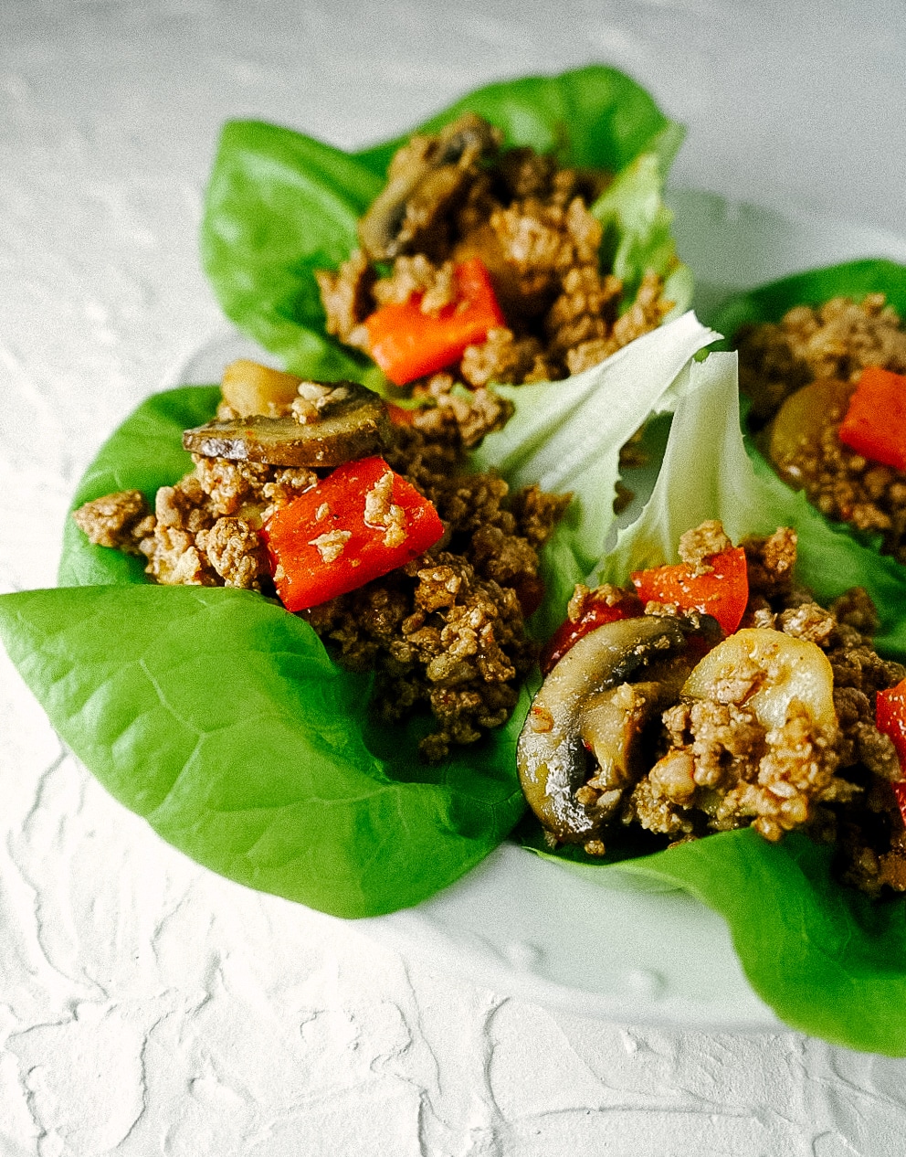 Three quarter view of pork lettuce wraps on a plate