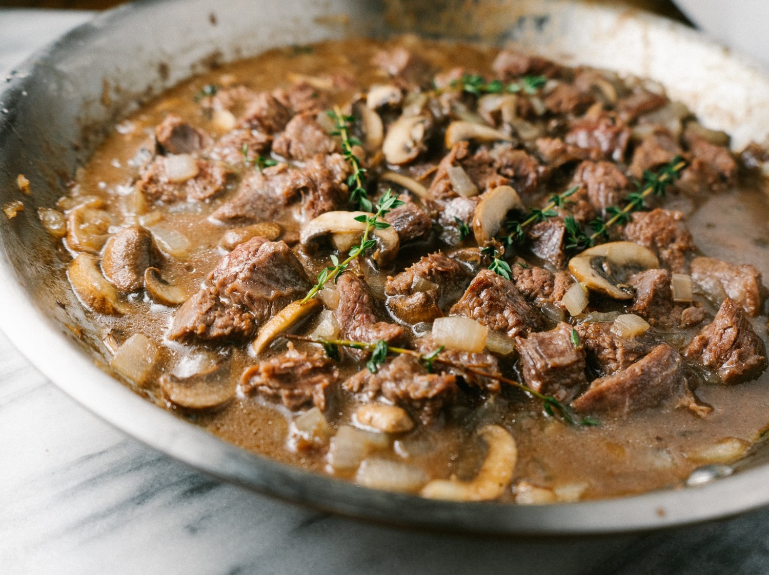 Three quarter view of a beef and mushroom recipe in a frying pan 