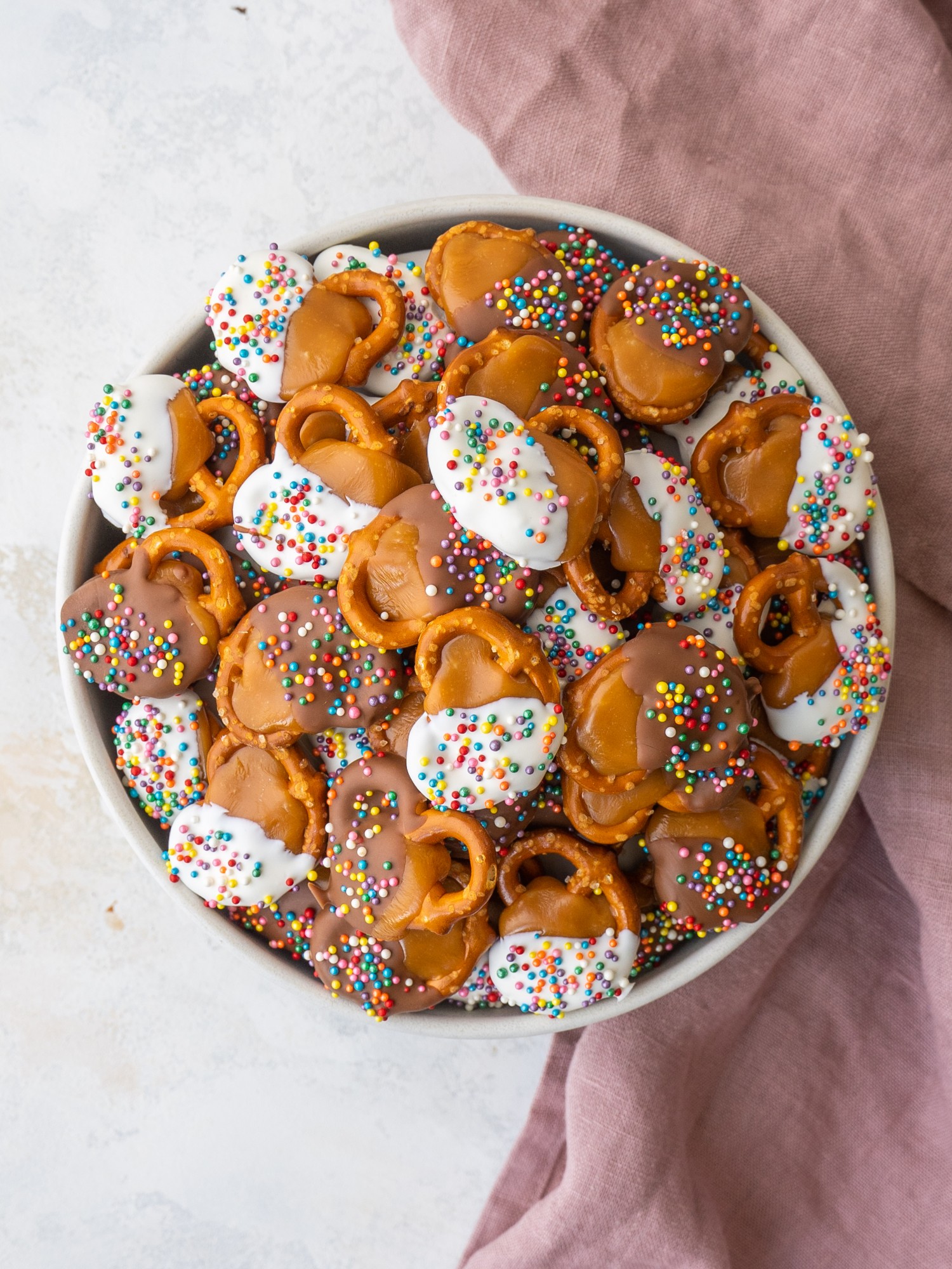 Above view of a bowl of chocolate caramel pretzel bits with rainbow sprinkles