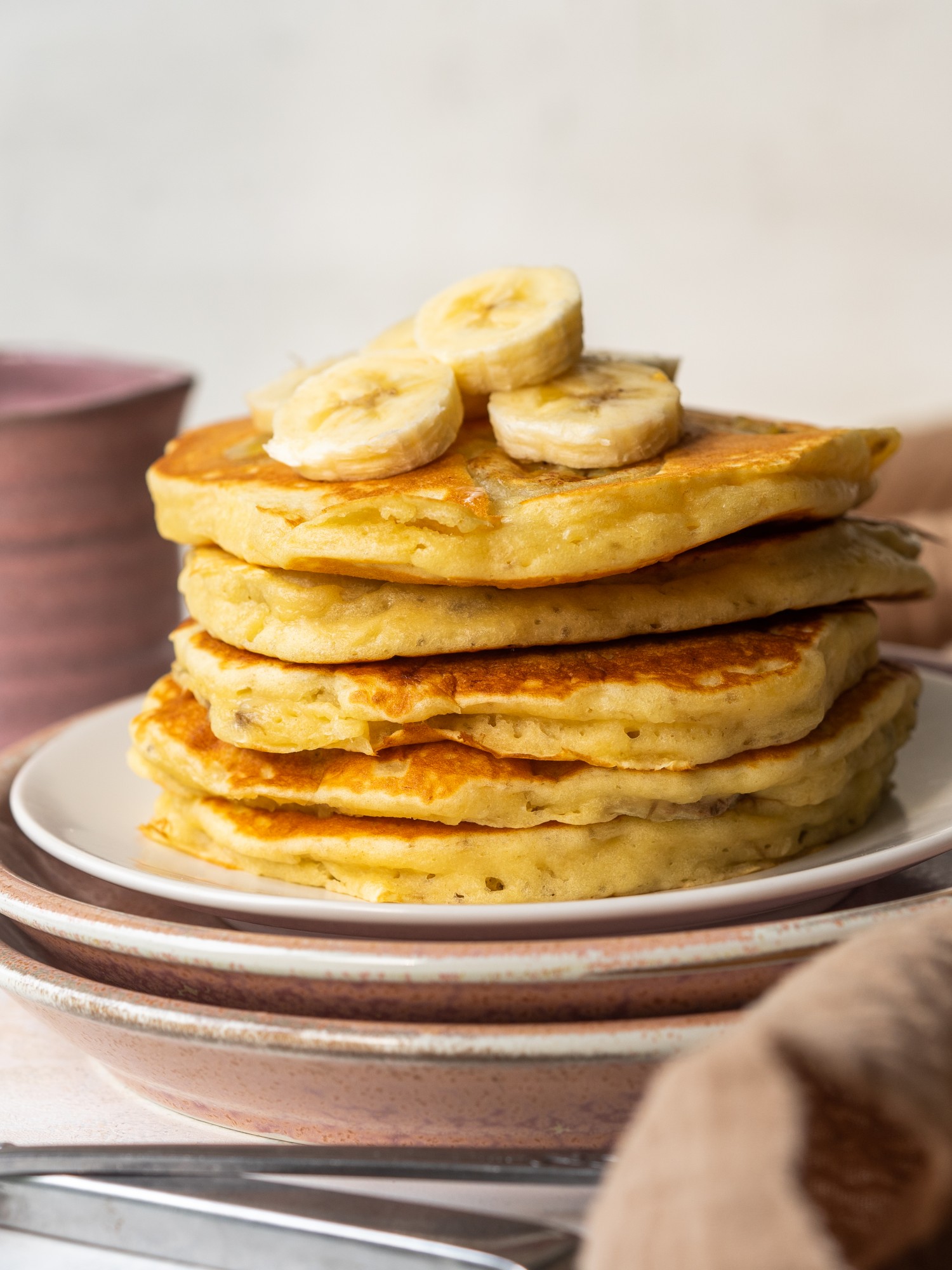 Side view of a stack of banana pancakes made with mashed bananas