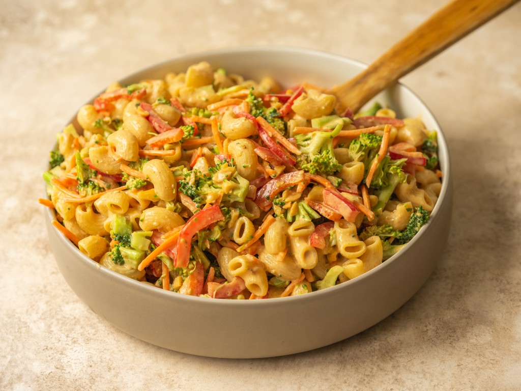 Three quarter view of peanut broccoli pasta salad in a serving bowl