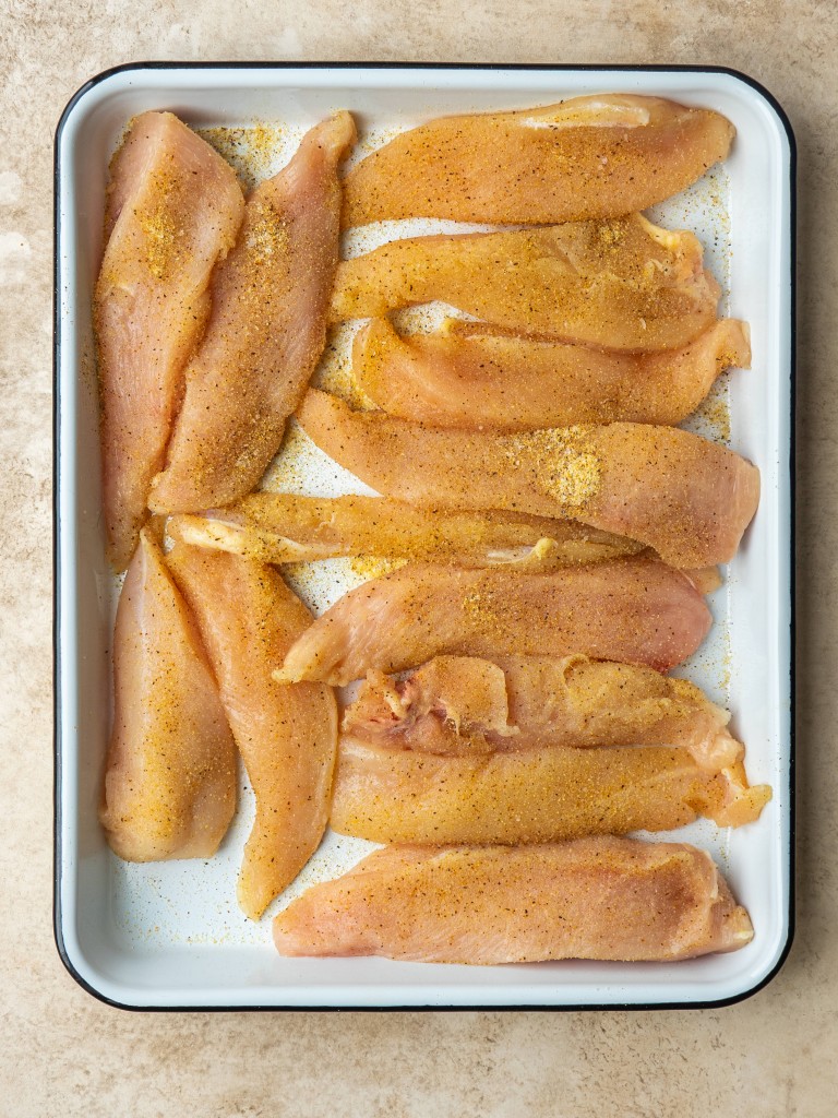 Seasoned chicken tenders on a tray