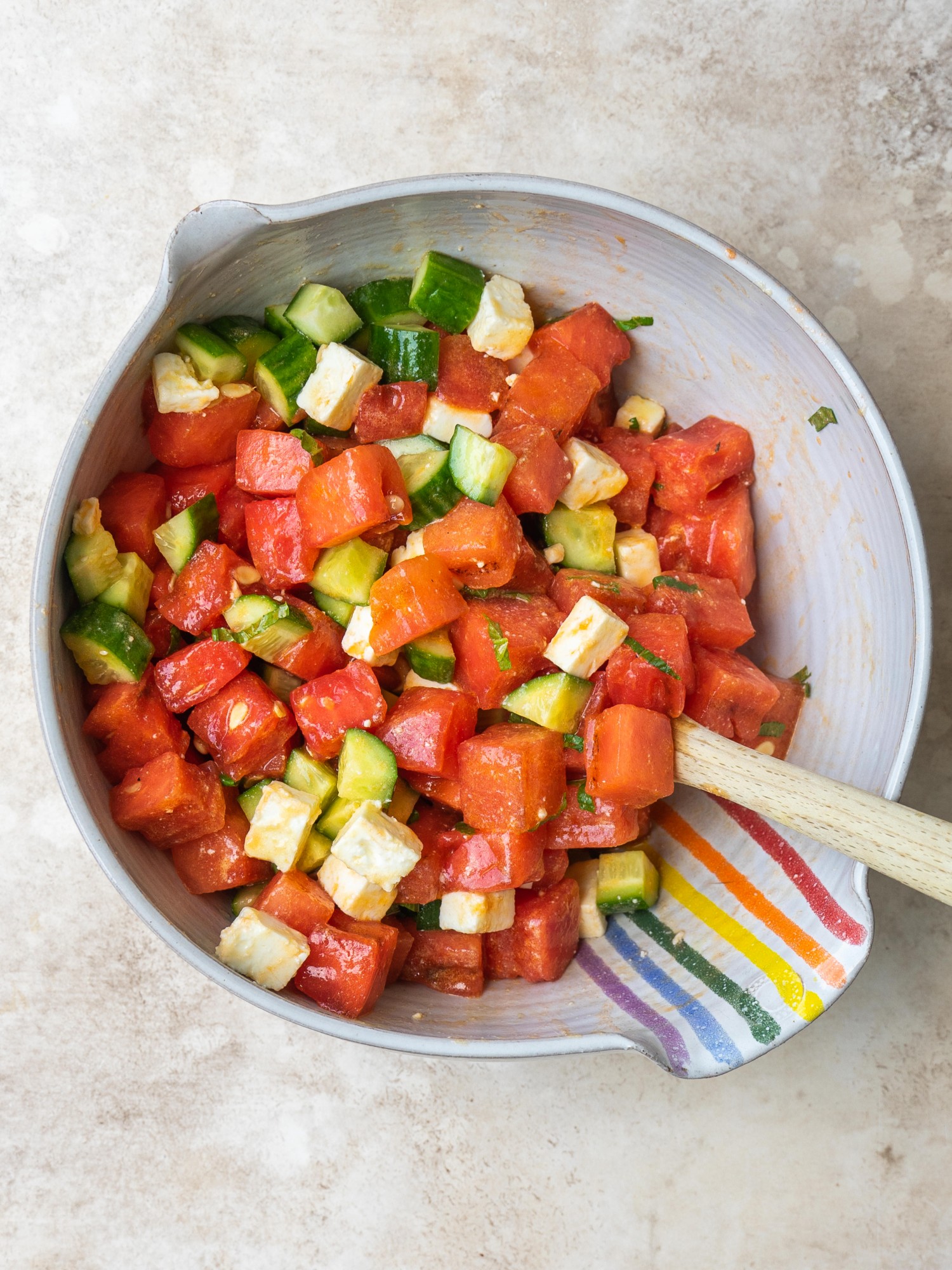 Above view of tossed grilled watermelon salad in a mixing bowl