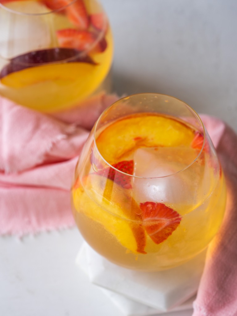 Three quarter view of white wine sangria with strawberries and peaches