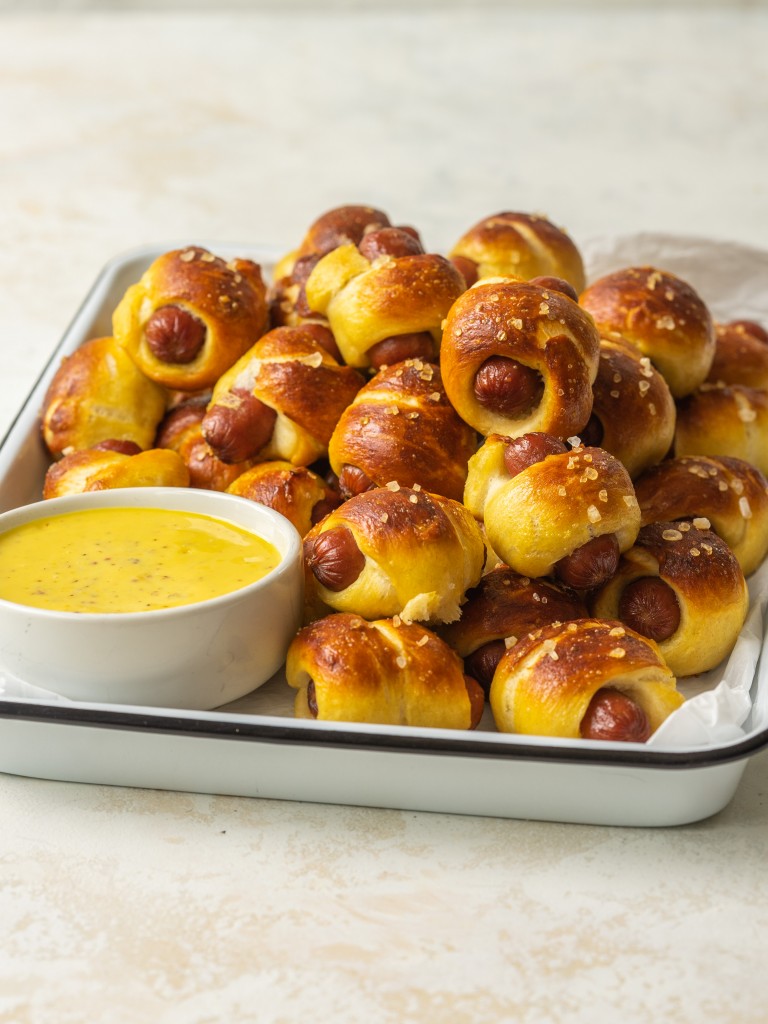 Side view of mini hot dogs made with a pretzel hot dog bun