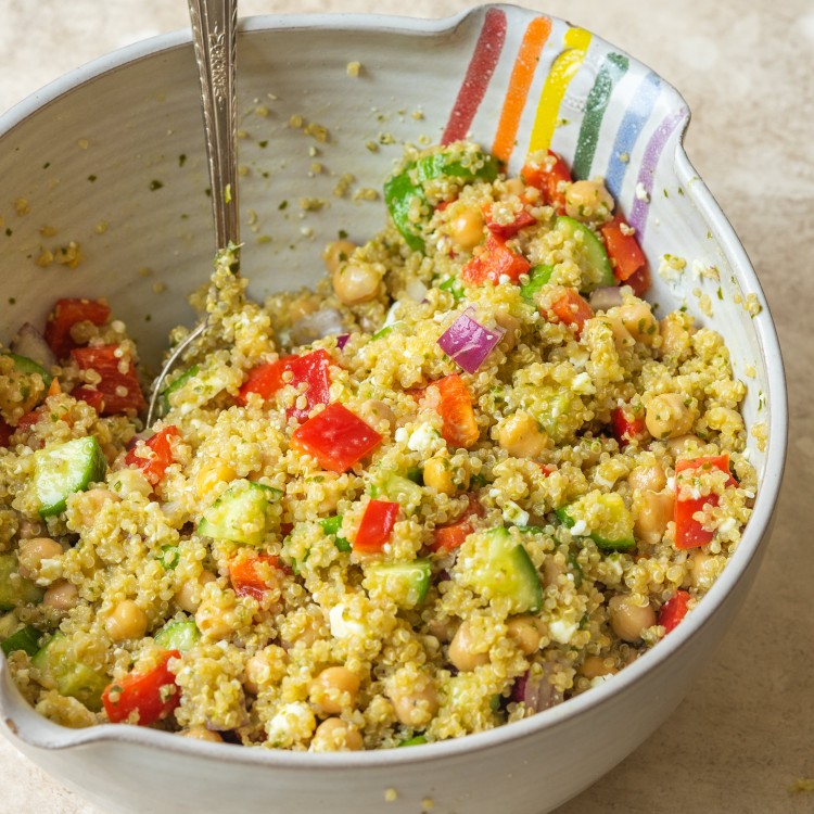 Quinoa chickpea salad with fresh veggies in a mixing bowl