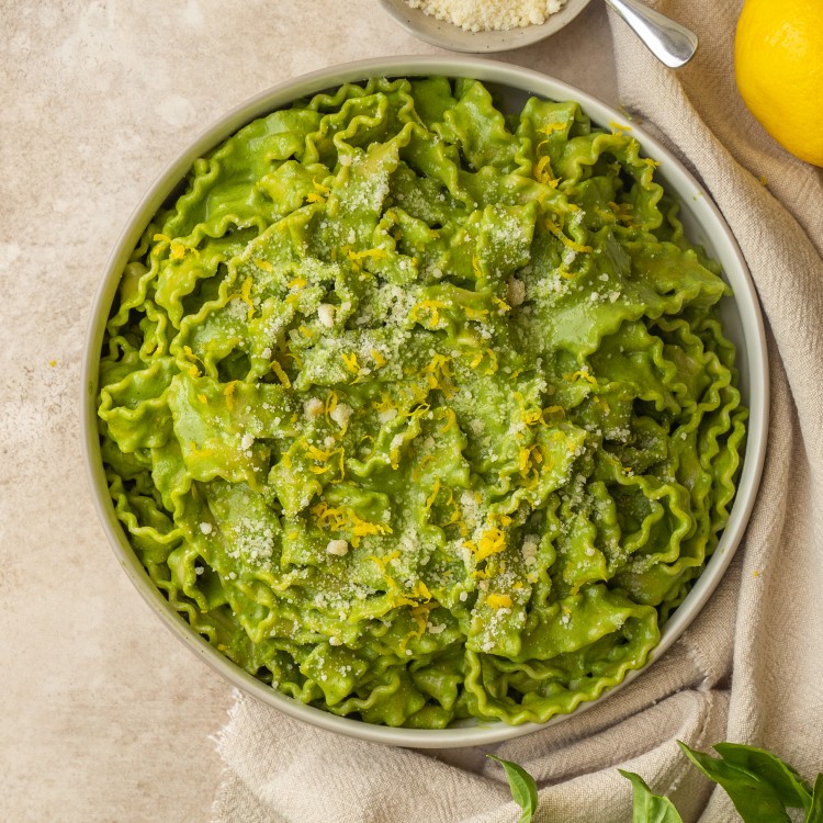 Above view of super green pasta sauce on mafaldine noodles in a serving bowl