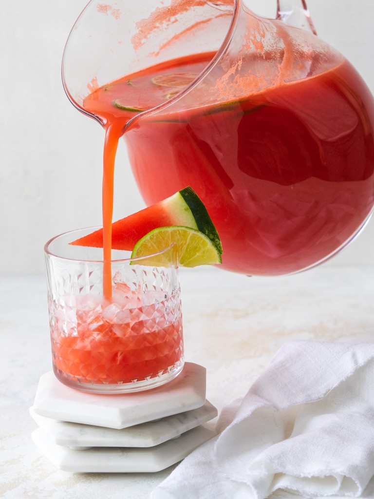 Watermelon cocktail pouring in a glass with ice