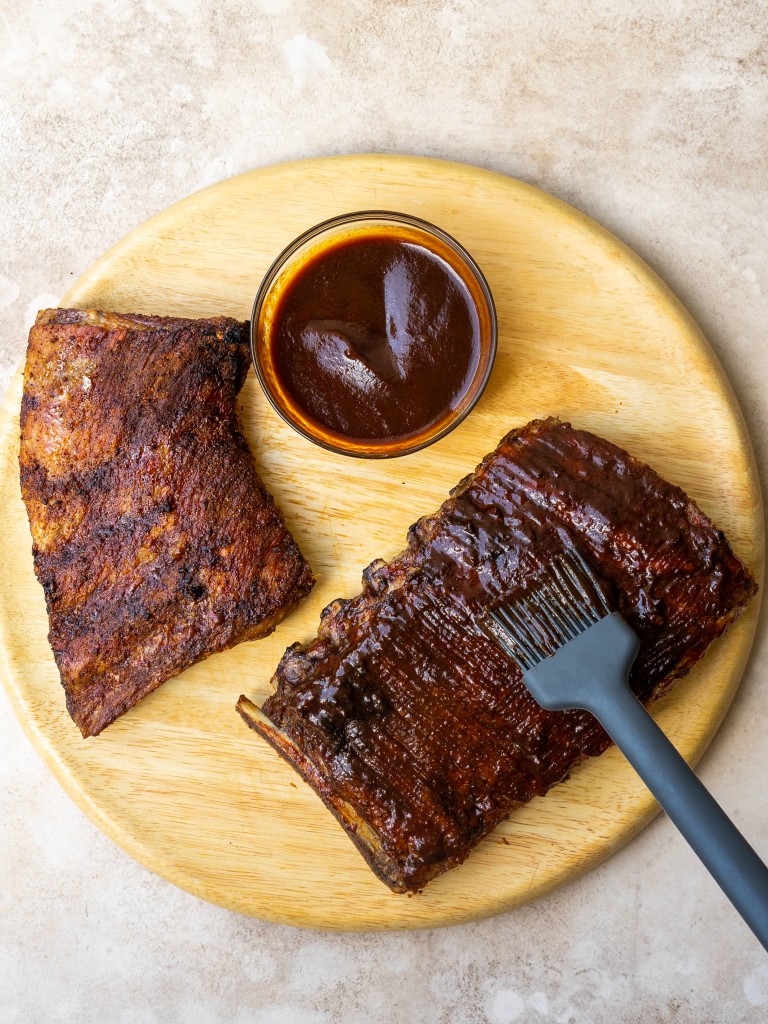 Above view of barbecue sauce brushing on air fryer ribs