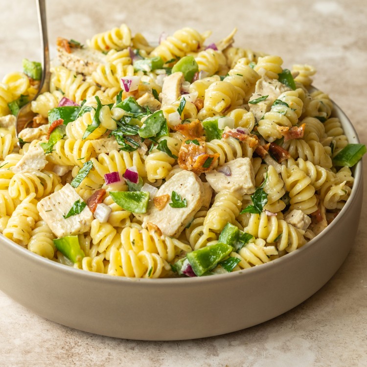 Three quarter view of a chicken bacon and ranch with pasta, parsley, bell pepper and red onion