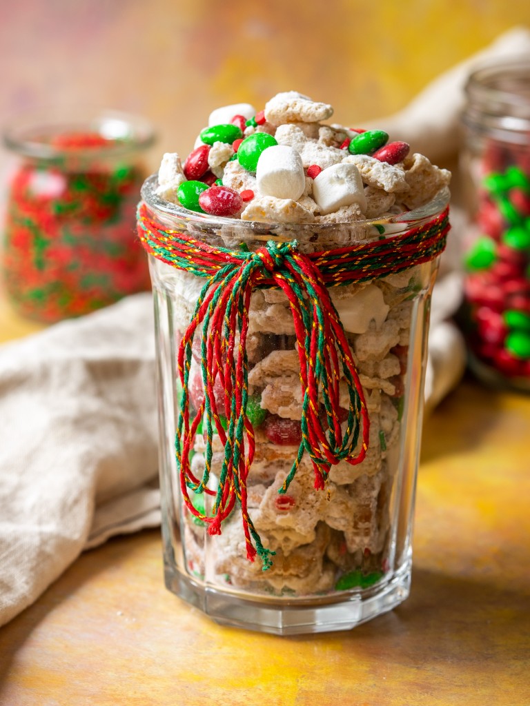 Side view of christmas crack chex mix in a festive jar