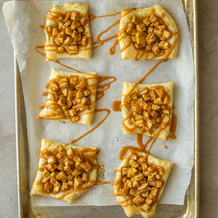 Above view of puff pastry apple tart on a sheet pan with caramel drizzle
