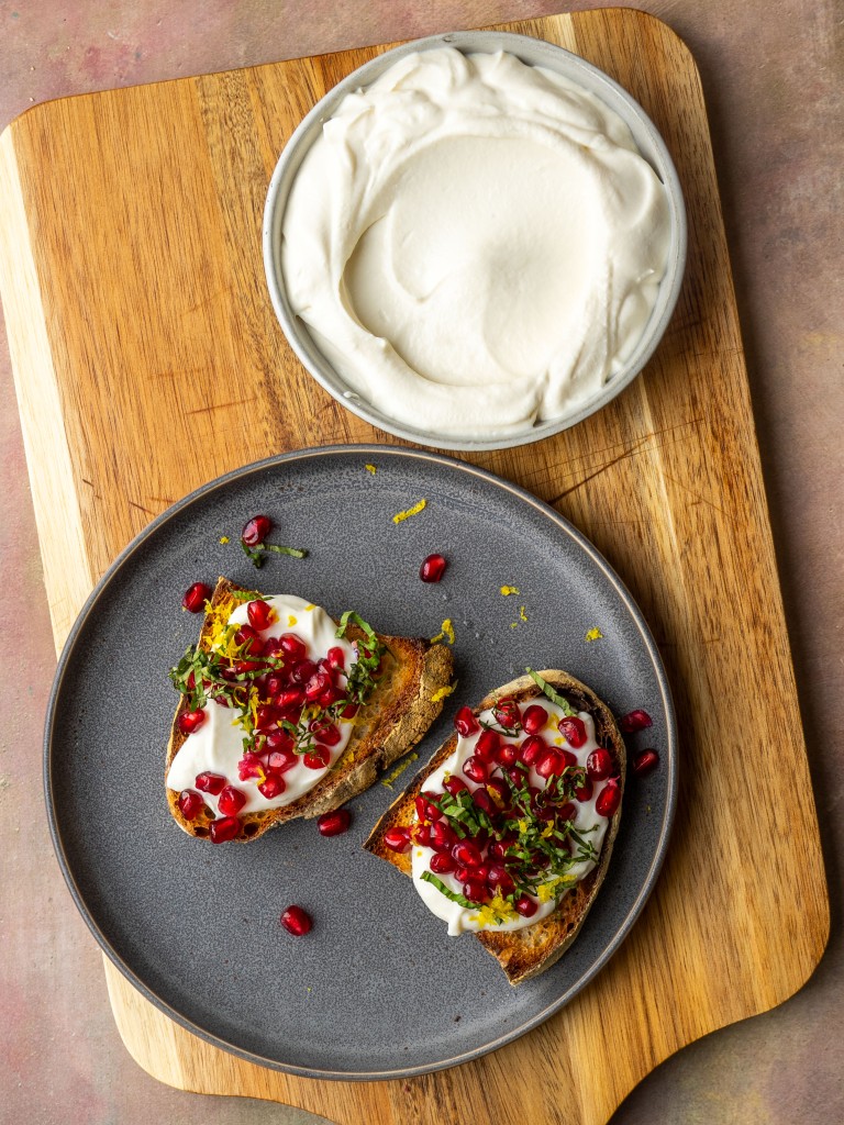 Above view of sweet whipped ricotta in a bowl next to a ricotta toast