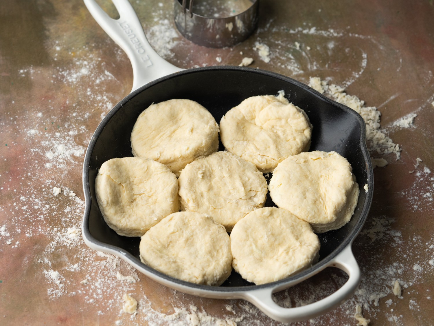Three quarter view of flaky biscuit dough in a cast iron skilley