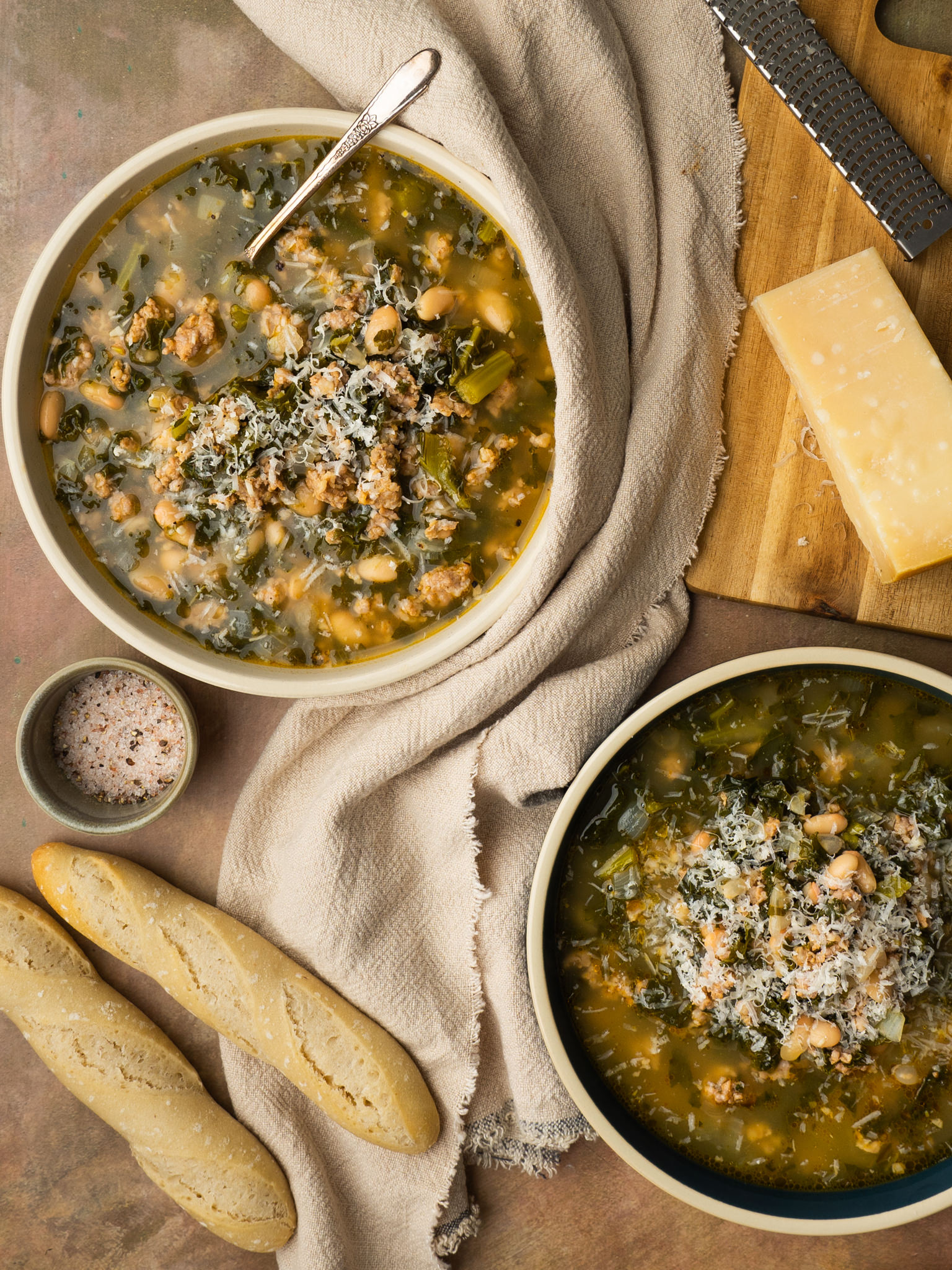 White bean and kale soup served with bread and parmesan cheese
