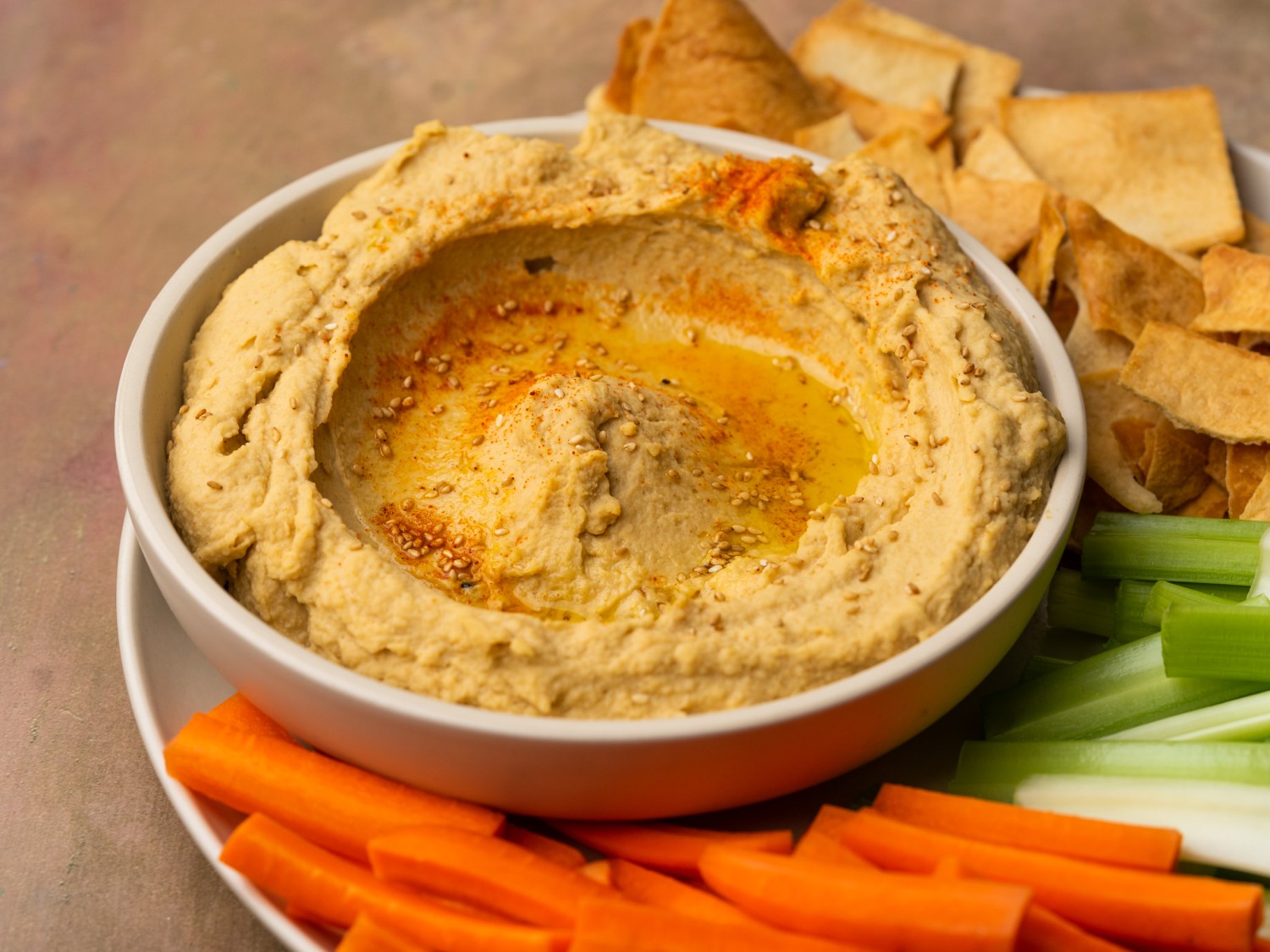 Side view of garlic hummus recipe in a serving bowl