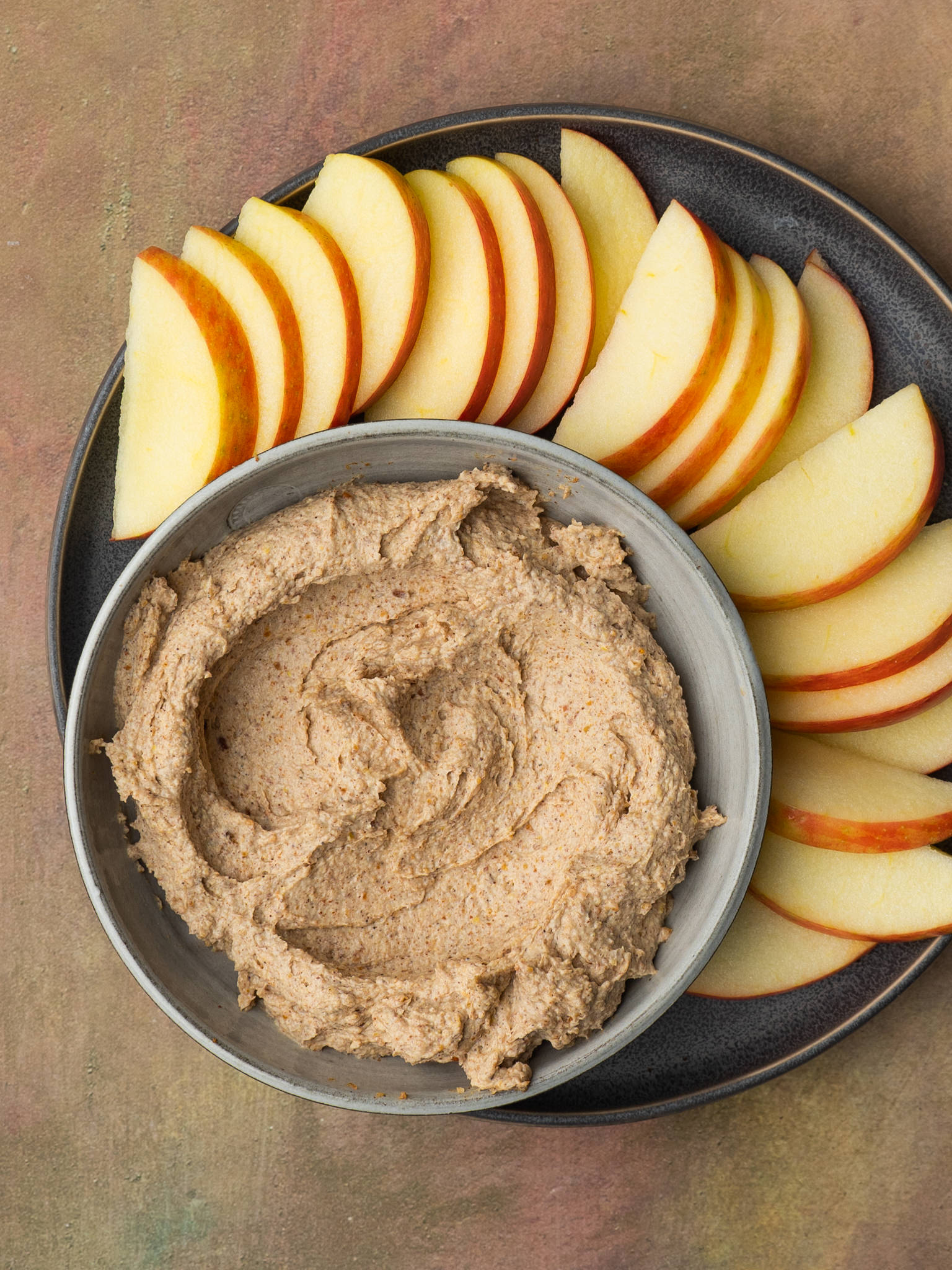 Above view of peanut butter dip served with sliced apples