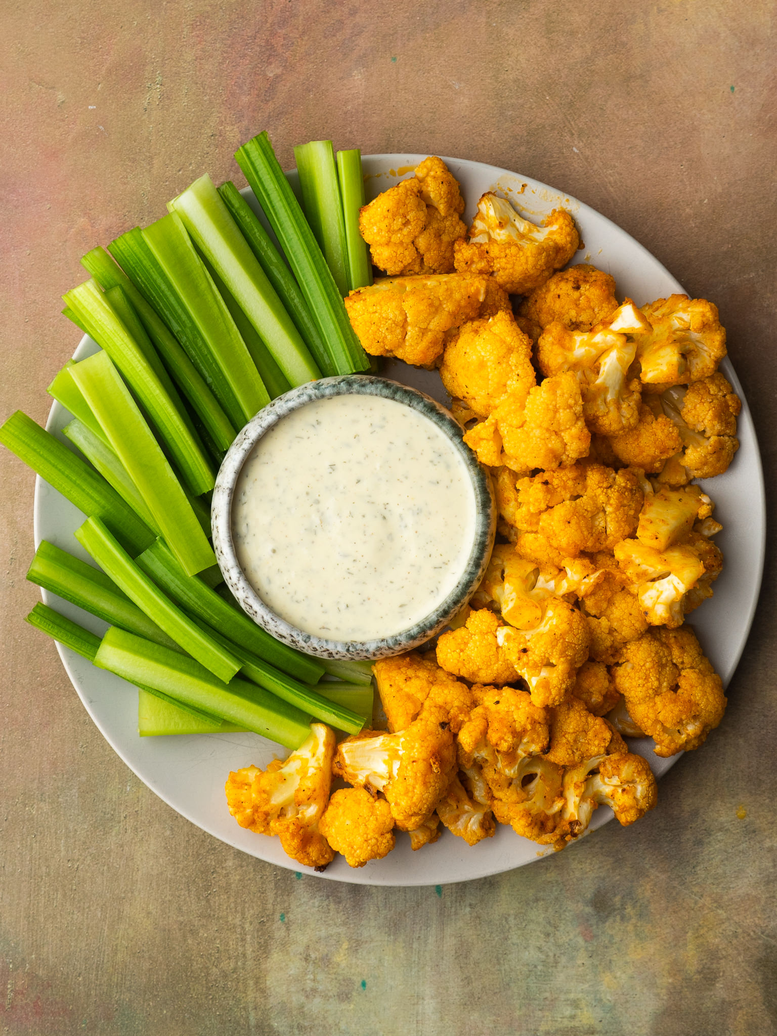 Buffalo cauliflower in air fryer with ranch dressing and celery