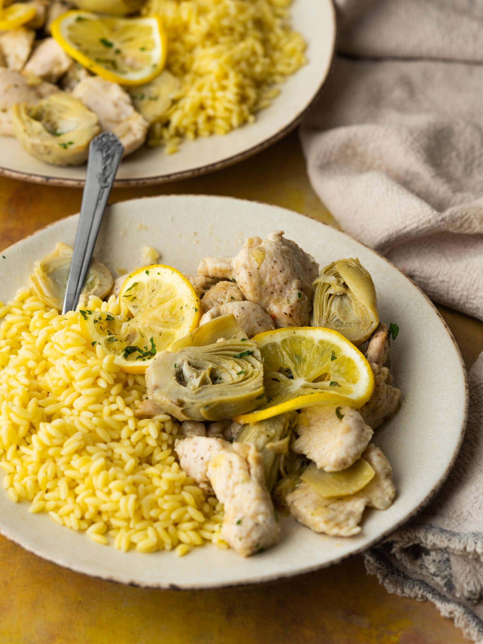 three quarter view of lemon artichoke chicken served with orzo