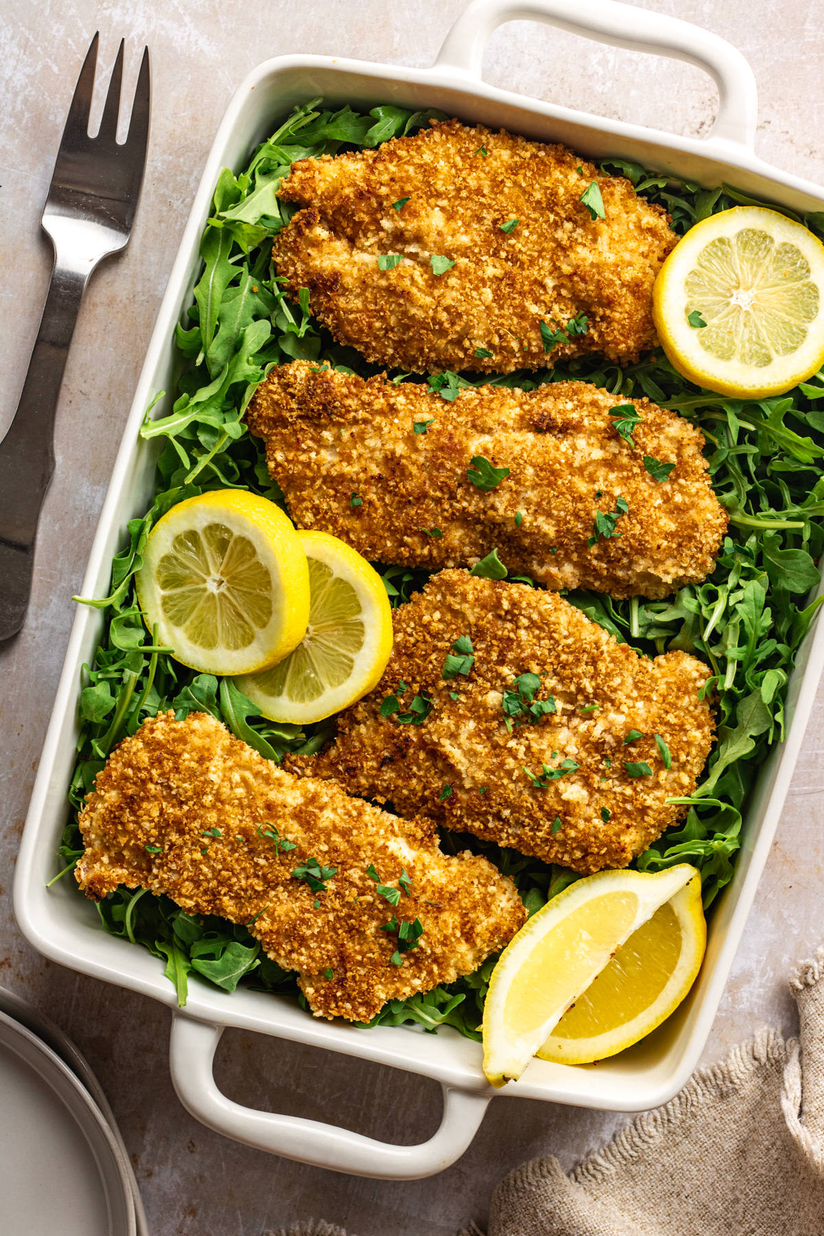 Above view of panko chicken breasts on a bed of arugula