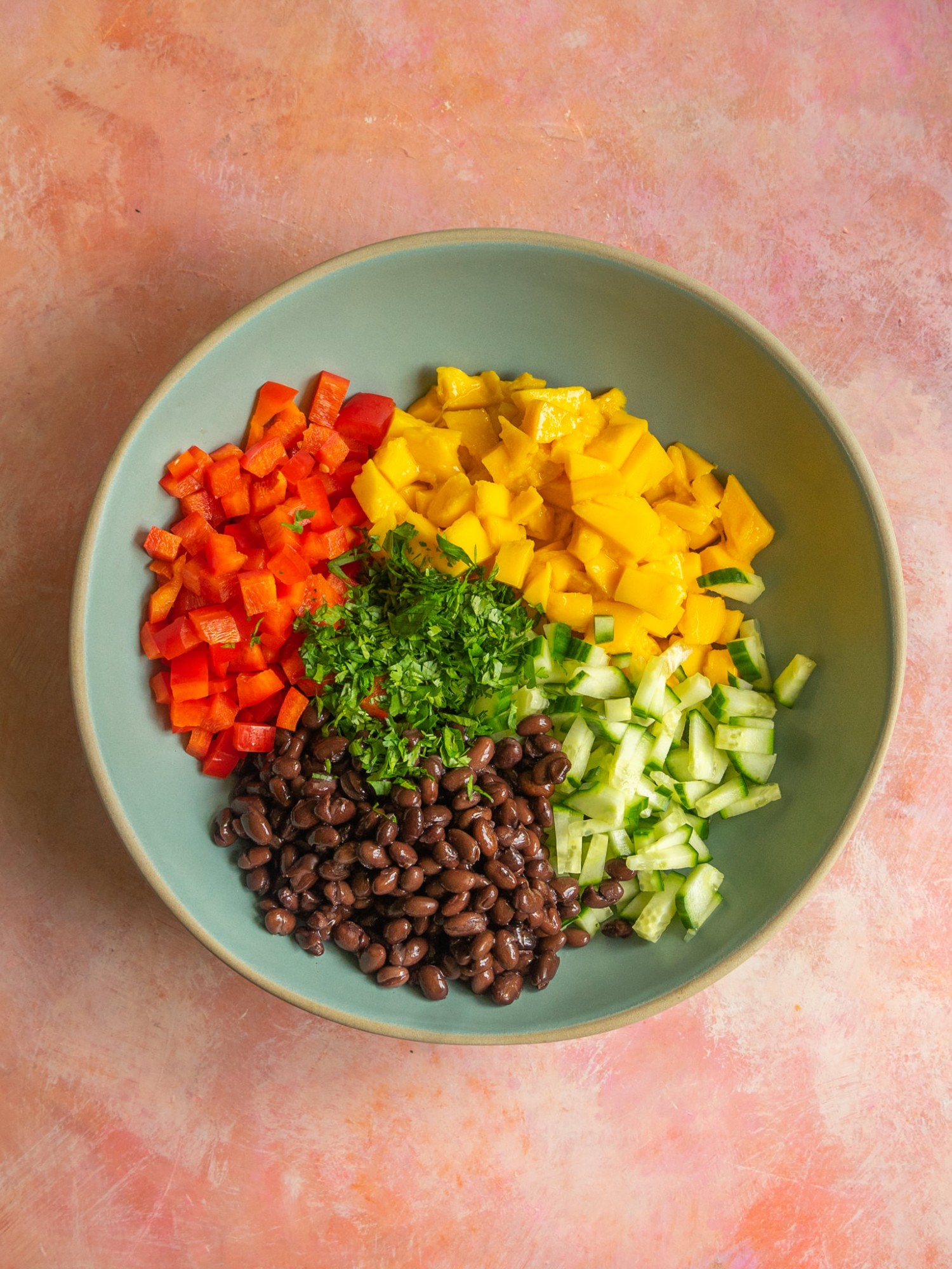 Mango and black bean salad ingredients in a mixing bowl