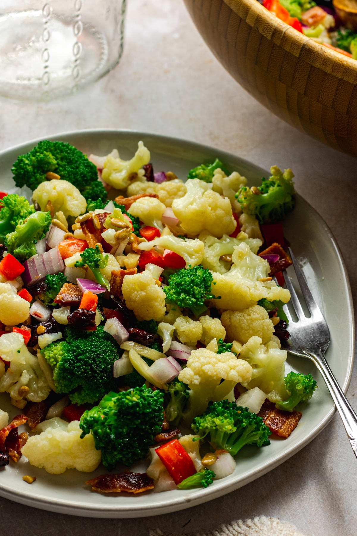 Three quarter view of broccoli bacon cauliflower salad on serving plate