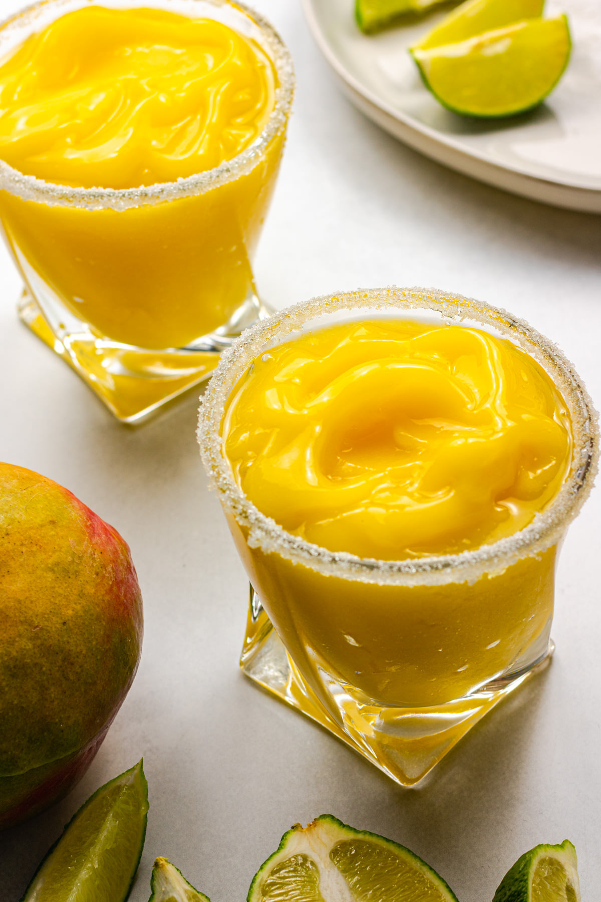 Two frozen mango margaritas in serving glasses
