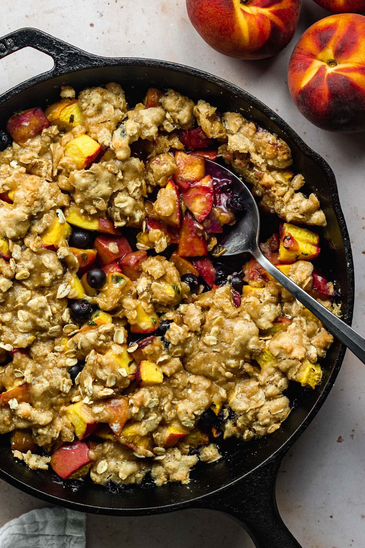 Above view of a peach and blueberry crisp with a spoonful scooped out
