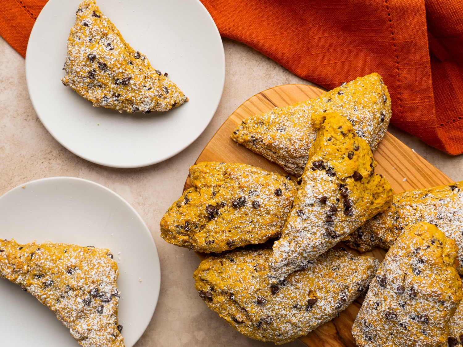 Chocolate chip scones on a serving board with powdered sugar on top