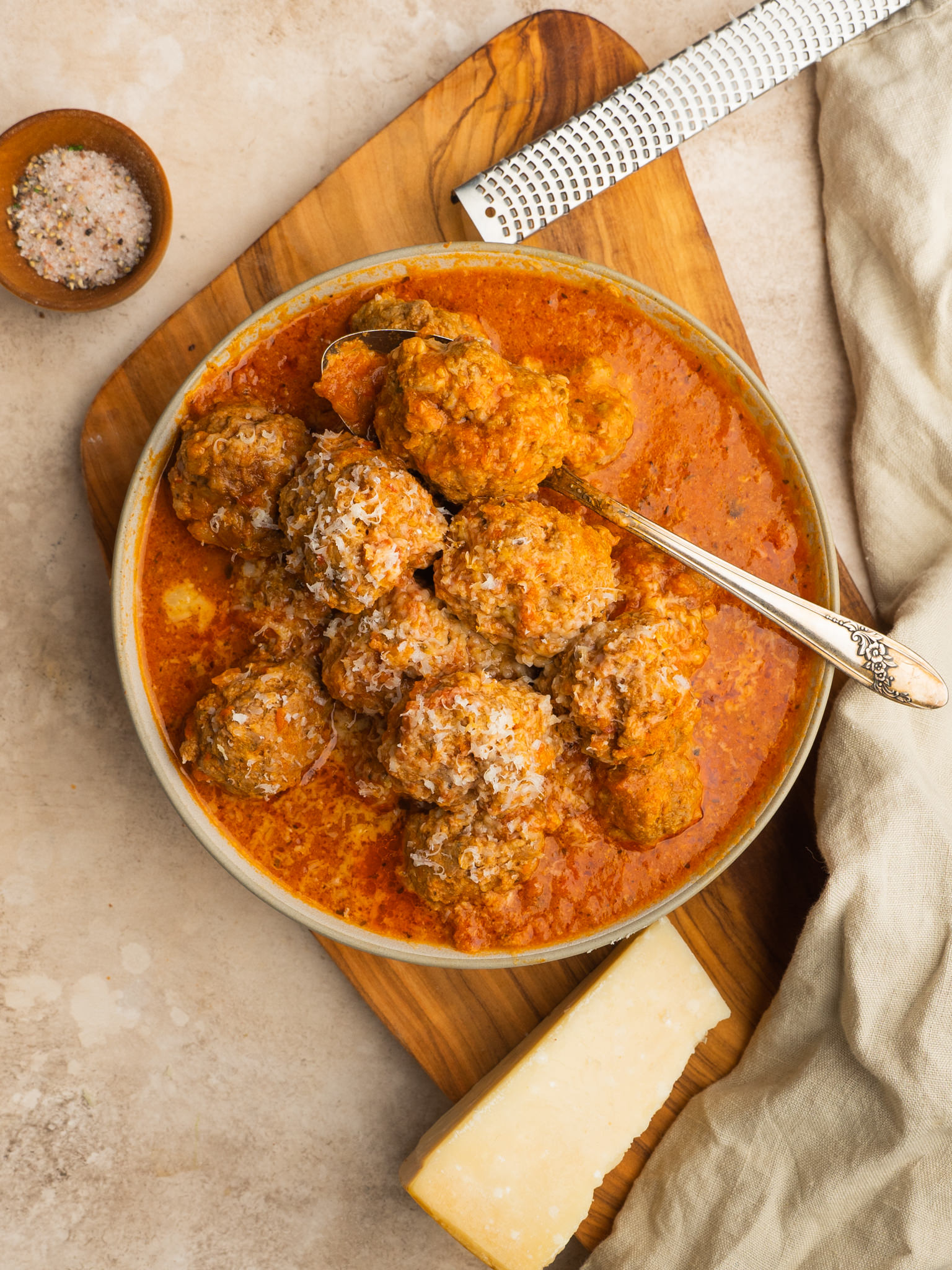 Slow cooker meatballs served with fresh parmesan cheese
