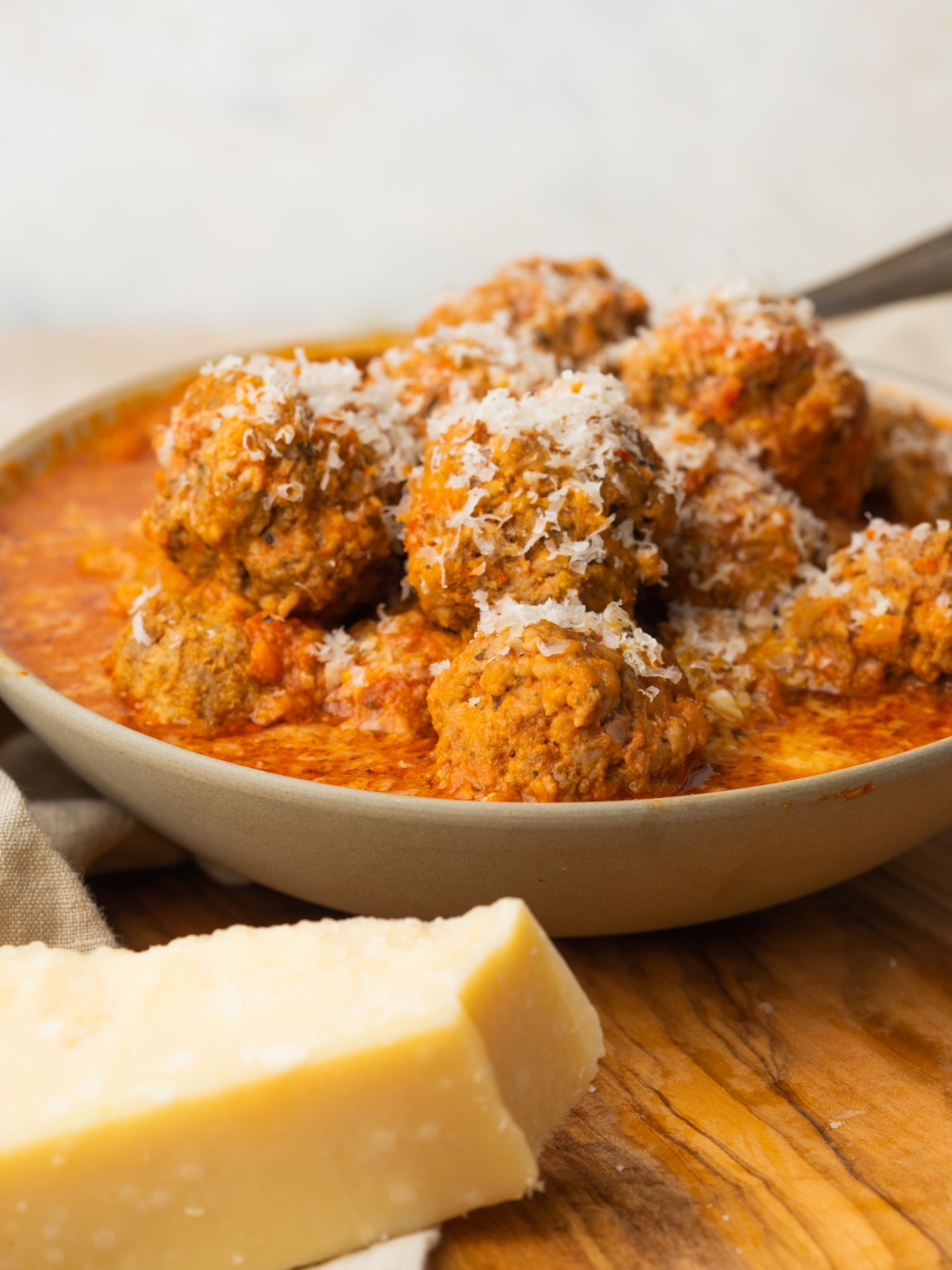 Side view of slow cooker meatballs recipe served with fresh parmesan cheese