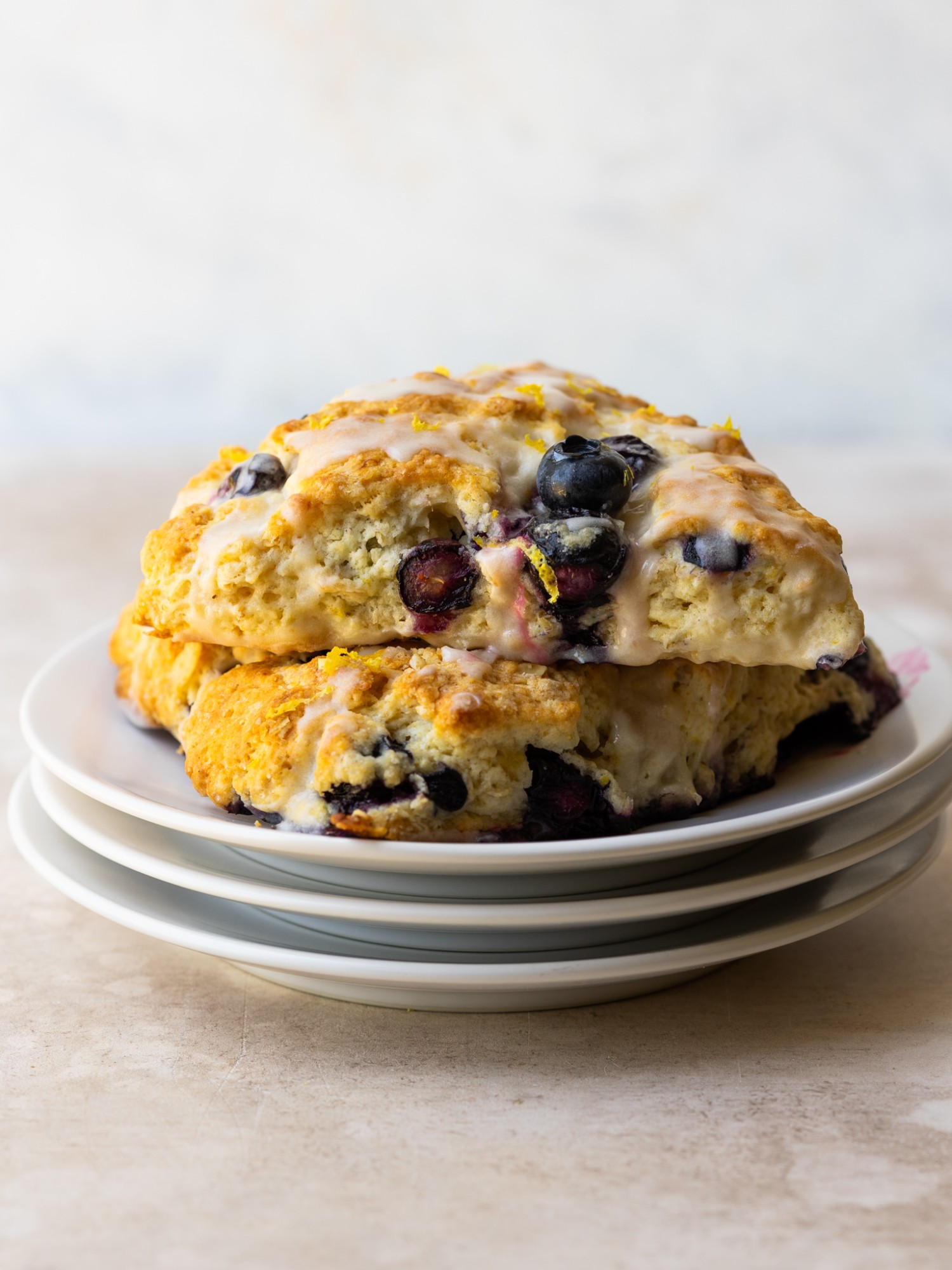 Side view of two blueberry lemon scones stacked on a serving plate