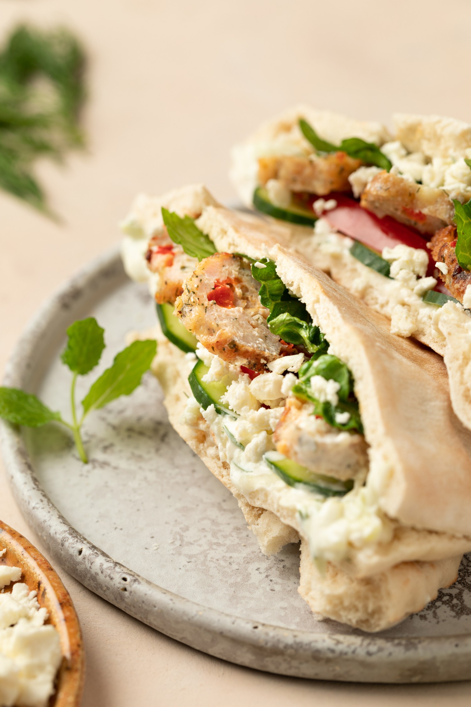 Side view of Greek chicken meatballs served in a pita