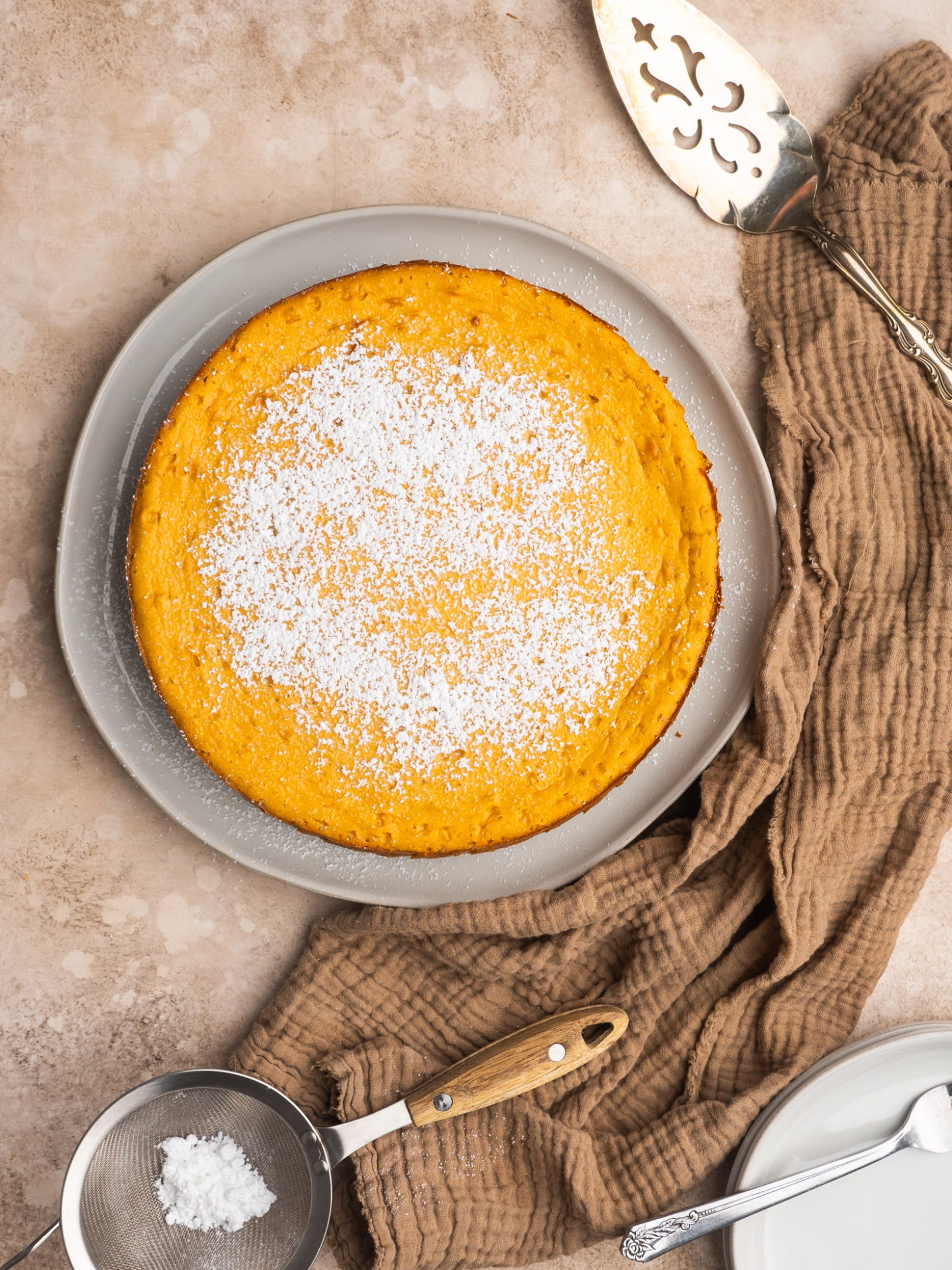 Above view of a cheesecake made with sweet potato with powdered sugar on top