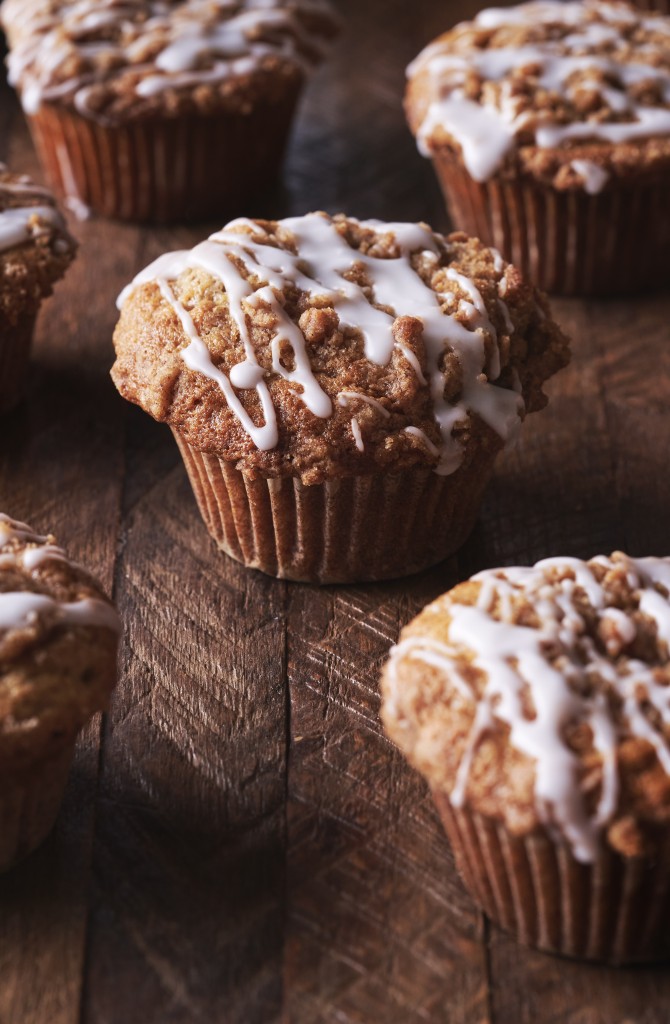 Several coffee cake muffins topped with a drizzle of icing