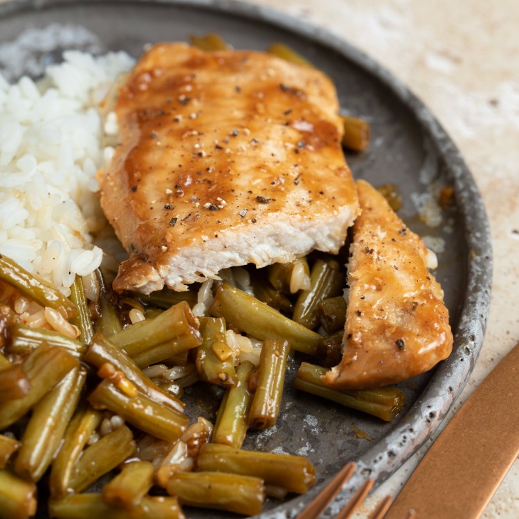 Honey garlic pork chop cut into slices and served with white rice and green beans