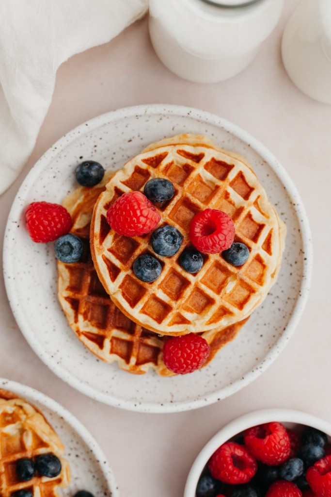 Above view of protein waffles on a plate with fresh berries
