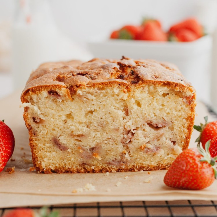 Side view of a loaf of strawberry pound cake with a slice cut off