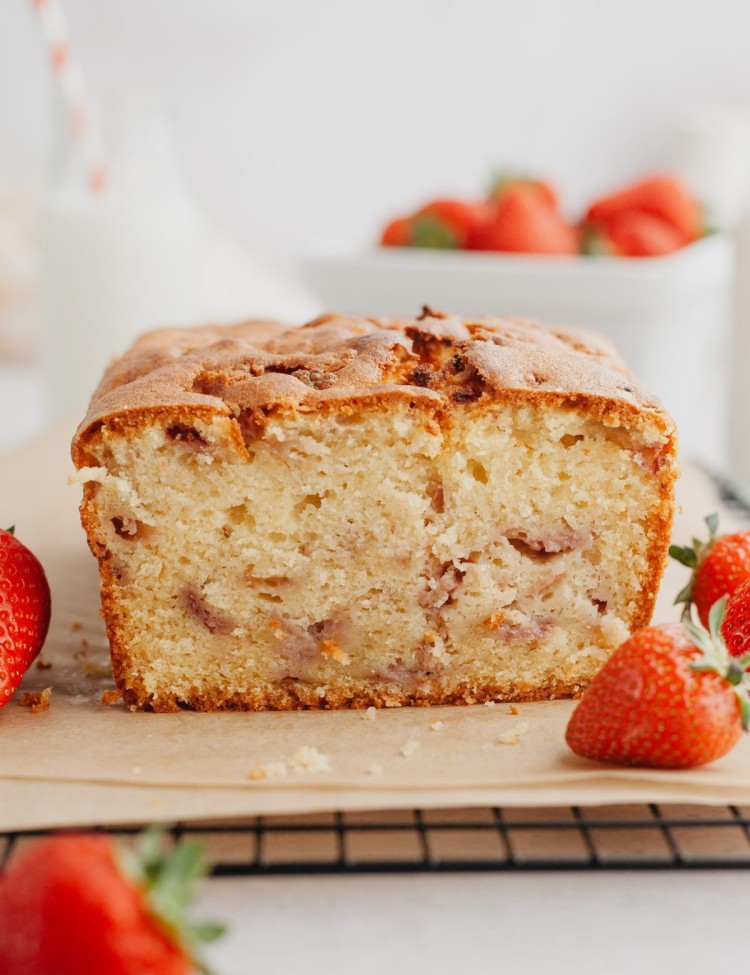 Side view of a loaf of strawberry pound cake with a slice cut off