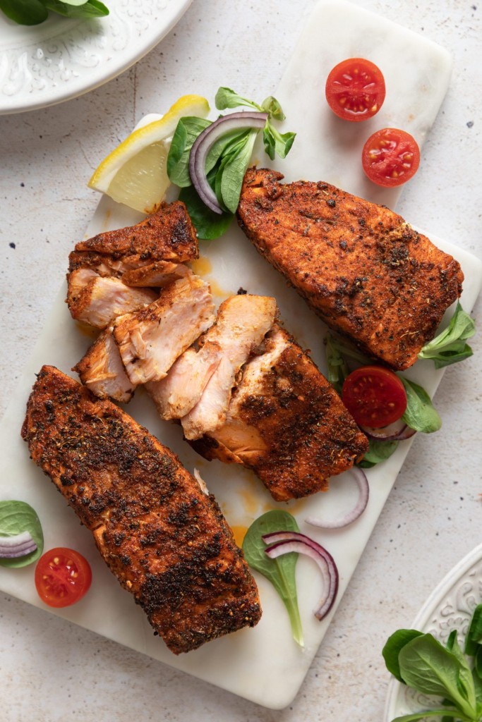 Above view of filets of blackened salmon on a serving board