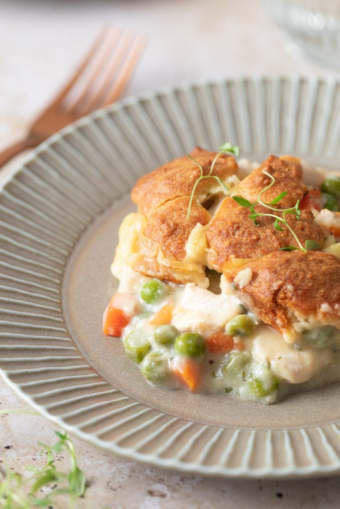 Three quarter view of a scoop of chicken pot pie casserole on a serving plate