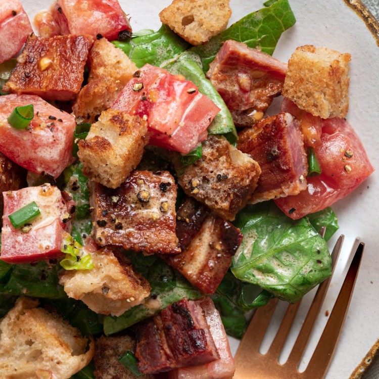 Close up above view of a BLT salad recipe on a serving plate with a gold fork next to it