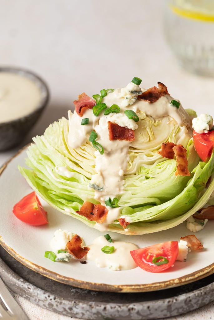 Side view of a wedge salad served with blue cheese dressing