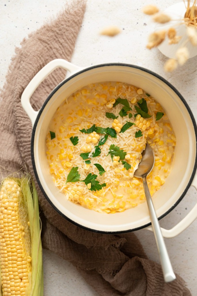 Above view of cream corn in a pot with a spoon