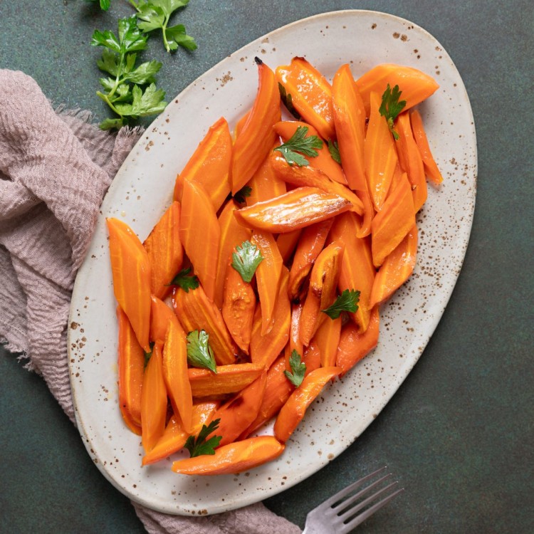 Maple carrots on a large serving platter garnished with fresh herbs