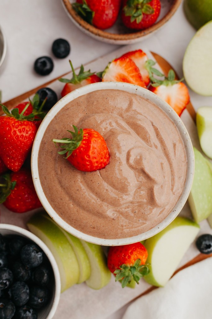 Above view of creamy chocolate dip for fruit served with strawberry