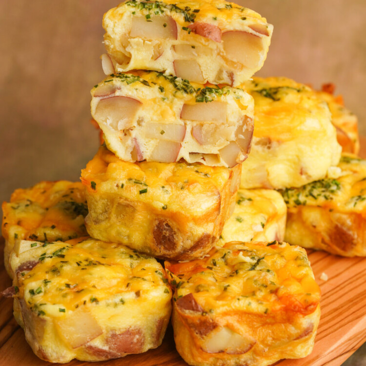 Side view of starbucks copycat potato cheddar chive bakes stacked up with the top egg bite cut in half so you can see the potatoes inside