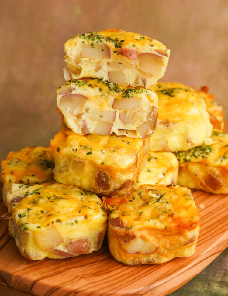 Side view of starbucks copycat potato cheddar chive bakes stacked up with the top egg bite cut in half so you can see the potatoes inside