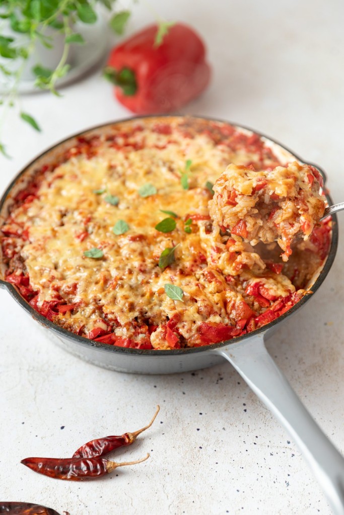 stuffed pepper casserole in a white pan with a scoop on a spoon 