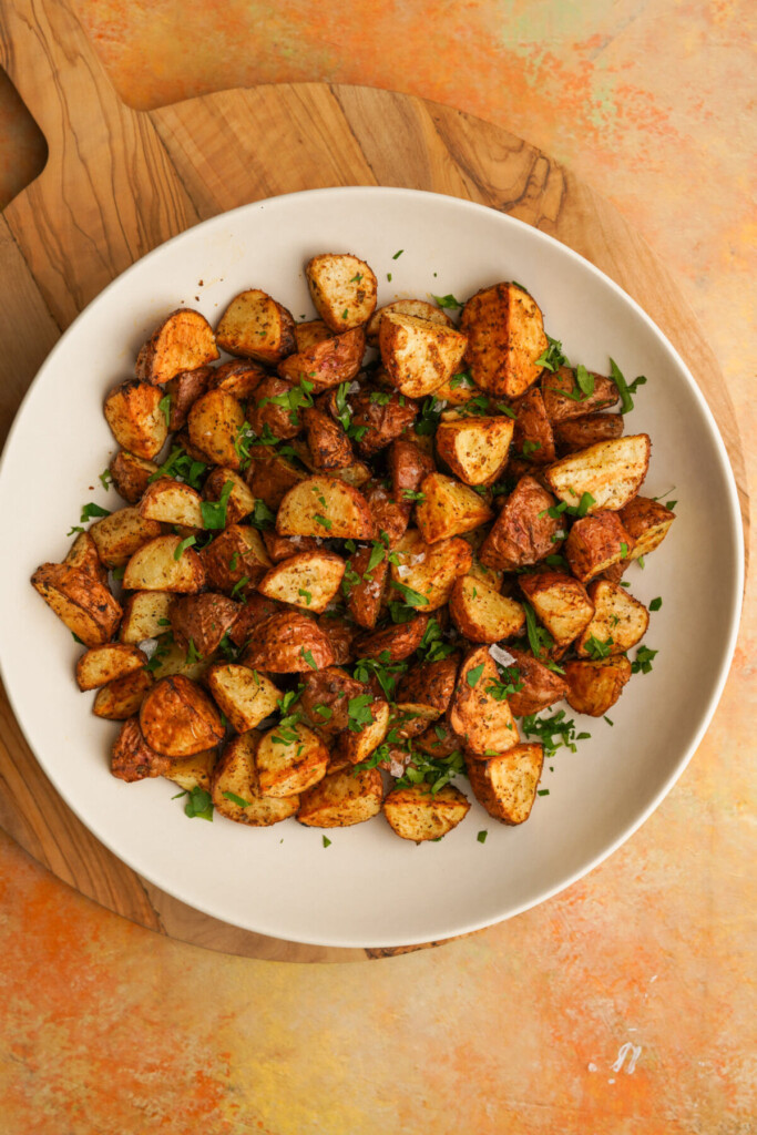 an above photo of air fryer red potatoes in a bowl with parsley on top 